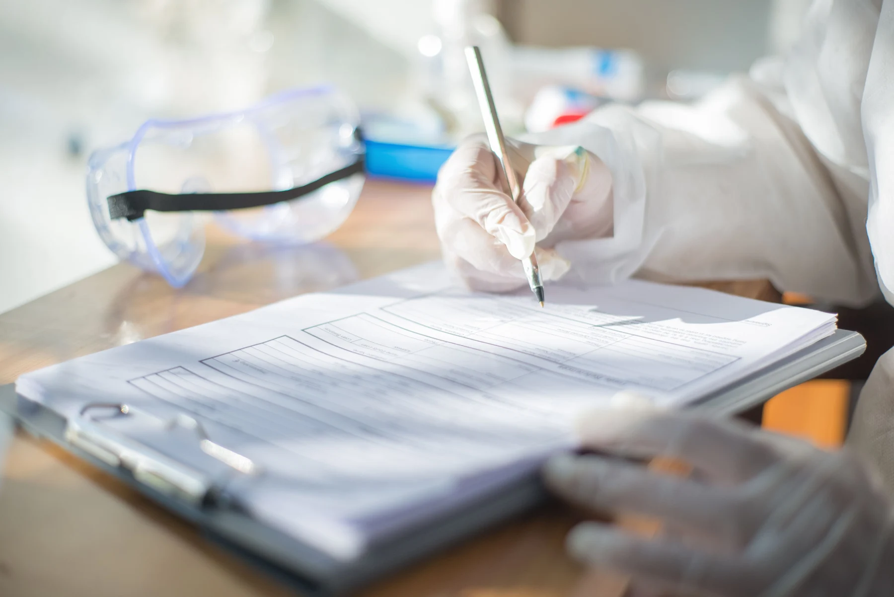 Gloved laboratory worker reviewing quality documentation